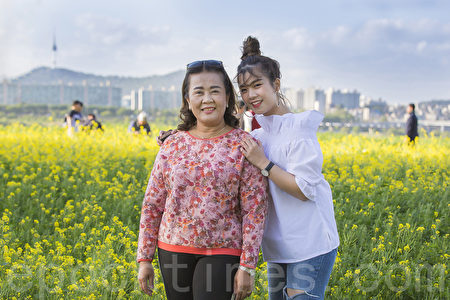 五月中旬的韩国首尔汉江瑞来岛（瑞草区盘浦地区）金黄的油菜花于汉江形成风景如画的美景。图为泰国游客在拍照留念。（全景林／媒体）