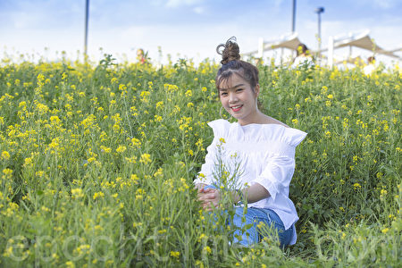 五月中旬的韩国首尔汉江瑞来岛（瑞草区盘浦地区）金黄的油菜花于汉江形成风景如画的美景。图为泰国游客在拍照留念。（全景林／媒体）